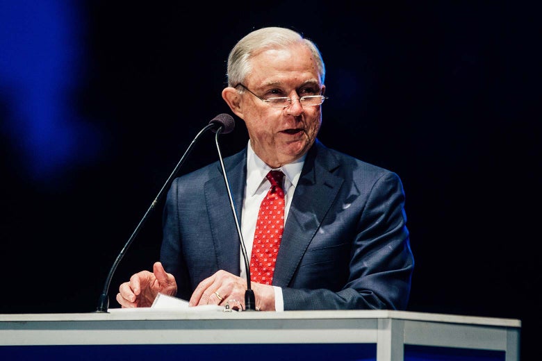 Jeff Sessions turns through his notes at a podium.